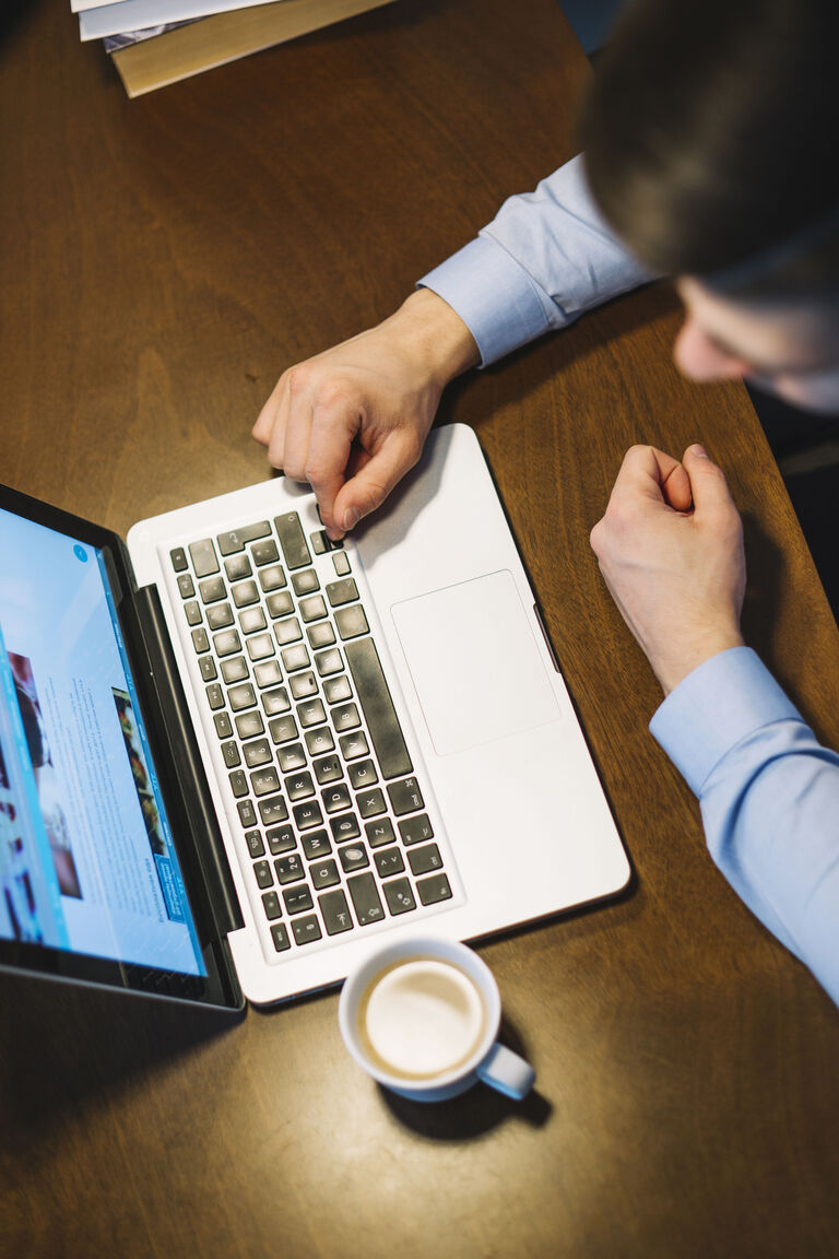 Self-Service-Kundenportal: Flexibler Kundenservice rund um die Uhr nutzen Mann am Laptop mit Kaffeetasse nutzt das Self-Service-Kundenportal früh am Morgen vor der Arbeit