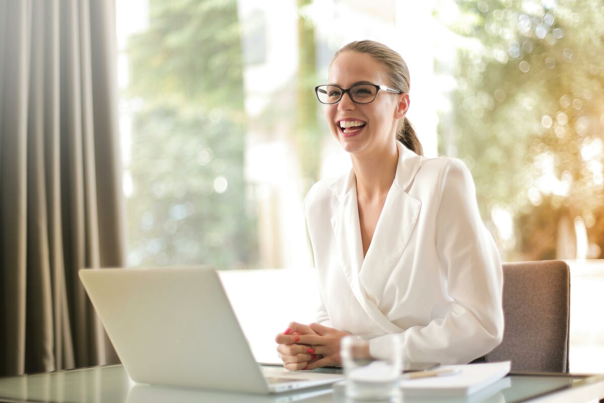 Frau lächelt am Computer und profitiert von einer effizienten, benutzerfreundlichen digitalen Suchtechnologie, die schnelle und relevante Suchergebnisse liefert.