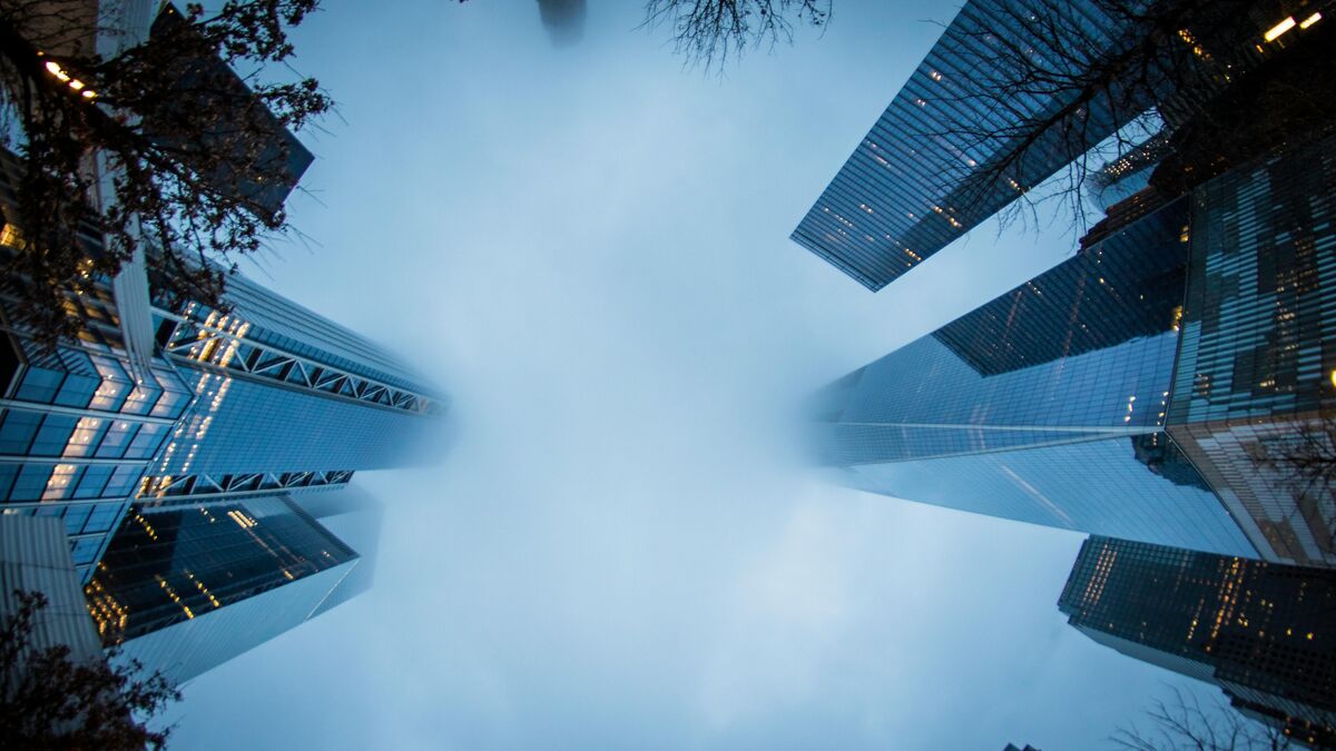 Froschperspektive auf moderne Hochhäuser im Nebel – Symbolbild für digitale Immobilienlösungen und zukunftsorientierte Projektentwicklung.