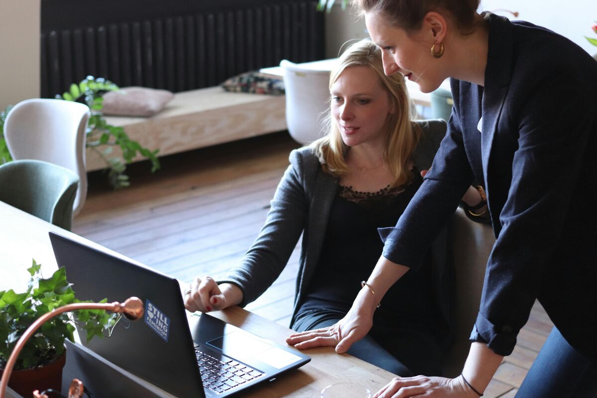 Zwei Frauen analysieren CMS-Inhalte und Workflows gemeinsam am Laptop