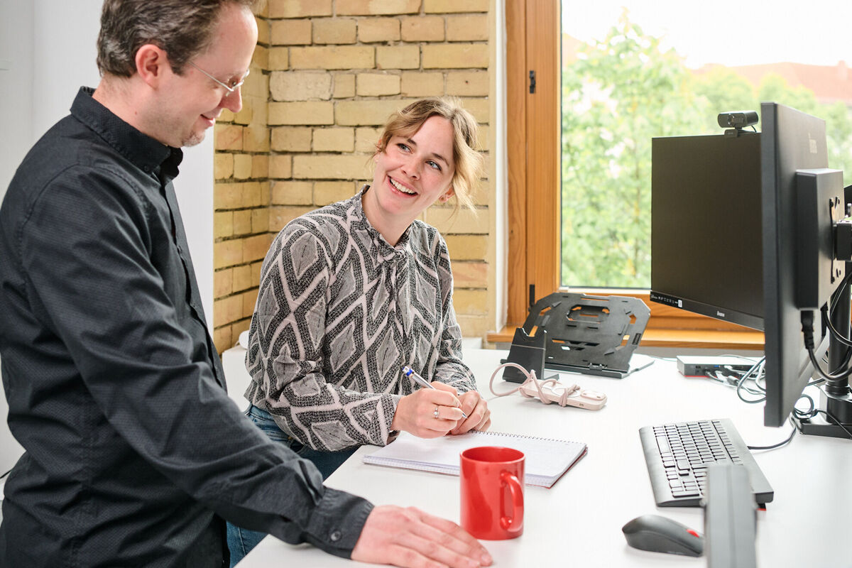 Dev-Team diskutiert DXP-Projekt Zwei Teammitglieder tauschen sich über innovative Softwareentwicklung für digitale Kundenerlebnisse aus